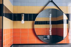 baño con espejo en la pared de azulejos en R&D Mucca Argentina, en Montale