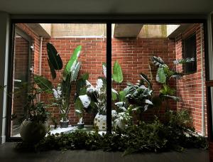 a window with plants in front of a brick wall at HHZib, homestay on a hill in the heart of Seoul in Seoul