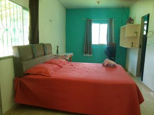 a bedroom with a bed with a red blanket at Sítio Família Morais in Salvaterra