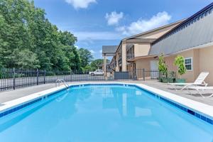 a swimming pool in front of a house at Super 8 Carrollton by Wyndham in Carrollton
