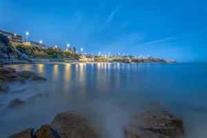 a beach at night with rocks in the water at Gold Coast Photography Inn in Estoril
