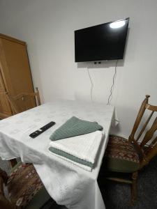 a white table with a television on a wall at Landgasthof Witten in Labenz