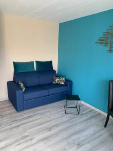 uma sala de estar com um sofá azul e uma mesa em LE BRON ACCUEIL - TOPDESTINATION-LYON em Bron