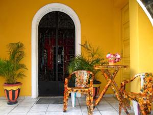 Casa amarilla con mesa, sillas y puerta en Arte Brasileira, en Salvador