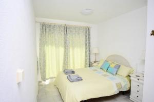 a white bedroom with a bed and a window at Seaviews Balcones de Chaparral 3 Bed Apt in Mijas Costa