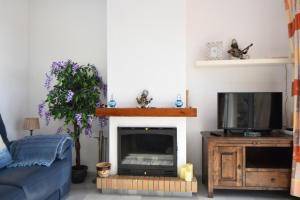 a living room with a fireplace and a tv at Seaviews Balcones de Chaparral 3 Bed Apt in Mijas Costa