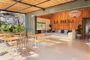 eine Terrasse mit Tischen, Stühlen und einem Sofa in der Unterkunft La Pausa Hotelbistro in Guatapé