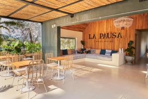 un patio con mesas y sillas y un sofá en La Pausa Hotelbistro en Guatapé