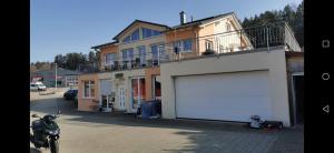 ein Motorrad, das vor einem Gebäude mit Garage geparkt ist in der Unterkunft Haus mit schöner Aussicht WG in Münsingen