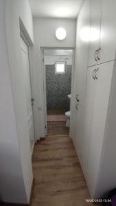 a hallway with a bathroom with a toilet and a door at Cavnic Hills Apartments in Cavnic
