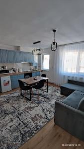 a living room with a table and a kitchen at Cavnic Hills Apartments in Cavnic
