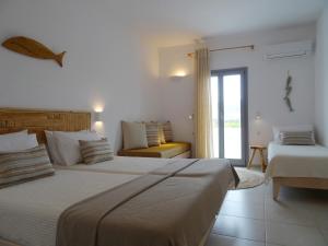a hotel room with two beds and a window at Paros Bay in Parasporos