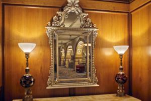 a mirror on a wall with two lamps on a table at The Brown Palace Hotel and Spa, Autograph Collection in Denver