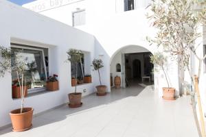 a hallway with potted trees on the side of a building at Paros Bay in Parasporos