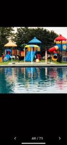 a childrens playground with a pool with play structures at Luxus Chalet „WASSERBLICK“ in Lathum