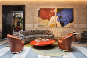 a lobby with a couch and a table and chairs at W Rome in Rome