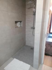 een badkamer met een douche met witte tegels bij Atlantic way Apartment in Sligo