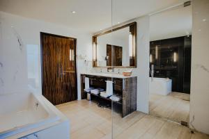 a bathroom with a tub and a sink and a mirror at Terrou-Bi in Dakar