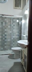 ein Badezimmer mit einem Waschbecken, einem WC und einem Spiegel in der Unterkunft Mandevilla Home in Caiazzo