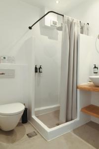 a bathroom with a shower with a toilet and a sink at Paros Bay in Parasporos