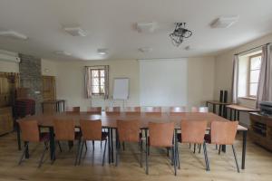 sala konferencyjna z dużym drewnianym stołem i krzesłami w obiekcie Penzion Ve stoleti w mieście Loděnice