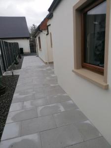 a stone walkway outside a house with a window at Atlantic way Apartment in Sligo
