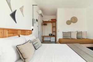 a bedroom with a large white bed with pillows at Paros Bay in Parasporos