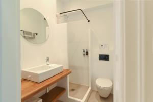a white bathroom with a sink and a toilet at Paros Bay in Parasporos