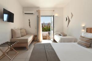 a hotel room with a bed and a couch and a television at Paros Bay in Parasporos