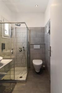 a bathroom with a glass shower and a toilet at Paros Bay in Parasporos