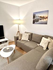 a living room with a gray couch and a tv at Keskuse apartment with a balcony in Haapsalu