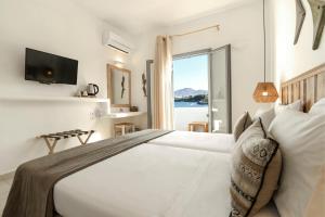 a bedroom with a bed with a view of the ocean at Paros Bay in Parasporos