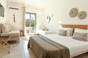 a bedroom with a bed and a chair and a window at Paros Bay in Parasporos