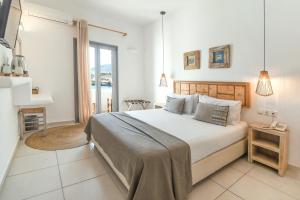 a bedroom with a large bed and a fireplace at Paros Bay in Parasporos