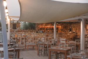 a restaurant with tables and chairs and a brick wall at Paros Bay in Parasporos