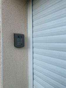 a remote control on the side of a garage door at LE BRON ACCUEIL - TOPDESTINATION-LYON in Bron +5 photos
