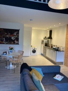 sala de estar con sofá, mesa y cocina en loods 14-2 en Groningen