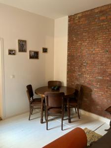 uma sala de jantar com mesa e cadeiras e uma parede de tijolos em Suikerrui 16 App 102 em Antuérpia