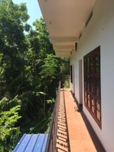 a balcony of a building with trees in the background at Alapatt Homestay in Alleppey