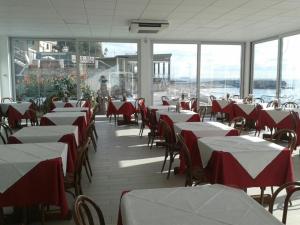 a restaurant with red and white tables and chairs at Hotel Bianca Maria in Varazze