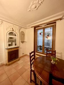a dining room with a table and a fireplace at Incroyable appartement parisien - Batignolles in Paris