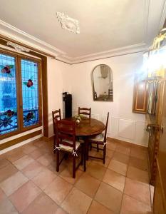- une salle à manger avec une table, des chaises et un miroir dans l'établissement Incroyable appartement parisien - Batignolles, à Paris