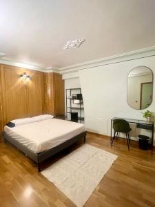 a bedroom with a bed and a mirror and a chair at Incroyable appartement parisien - Batignolles in Paris