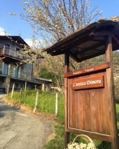 a wooden sign for the entrance to at L'Antica Dimora in Perosa Argentina