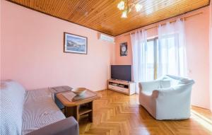 uma sala de estar com um sofá, uma mesa e uma televisão em Cozy Apartment In Dinjiska With Kitchen em Dinjiška