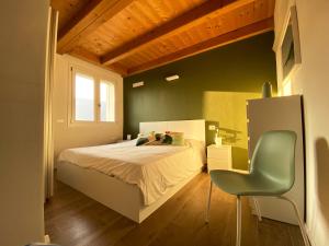 a bedroom with a bed and a green chair at Sol Lakeview in Sale Marasino