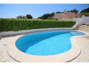a swimming pool in a yard with a hedge at Belvilla by OYO Casa Patricia in Altea la Vieja