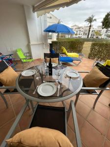 a glass table with chairs and an umbrella on a patio at Casa El Tonelero, Casa Del Pequeno Tonelero & Casa Del Gran Tonelero - by El Tonelero Ltd in Sucina