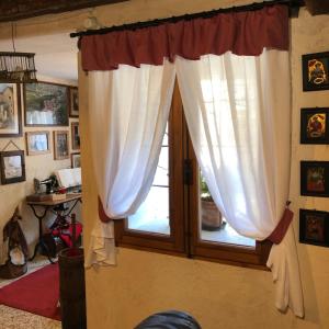 una ventana con cortinas blancas en una habitación en Casa Stayerat-holiday home Segusino-Valdobbiadene, en Sequsino
