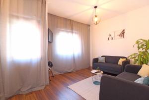 ein Wohnzimmer mit einem Sofa und einem Fenster in der Unterkunft Laranjal Guesthouse in Vila do Conde